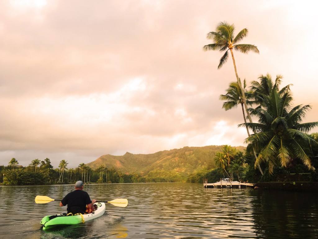 Man Kayaks On Wailua River As Early Morning Light Baths The Sky