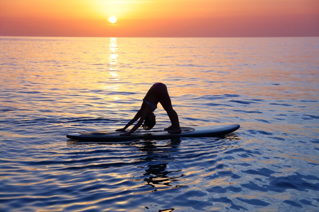 Sportive Female Doing Yoga Exercise On The Beach