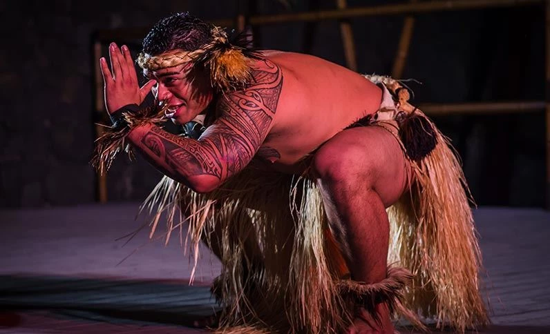 Voyagers Of The Pacific luau: male dancer in traditional Polynesian wear with tattos